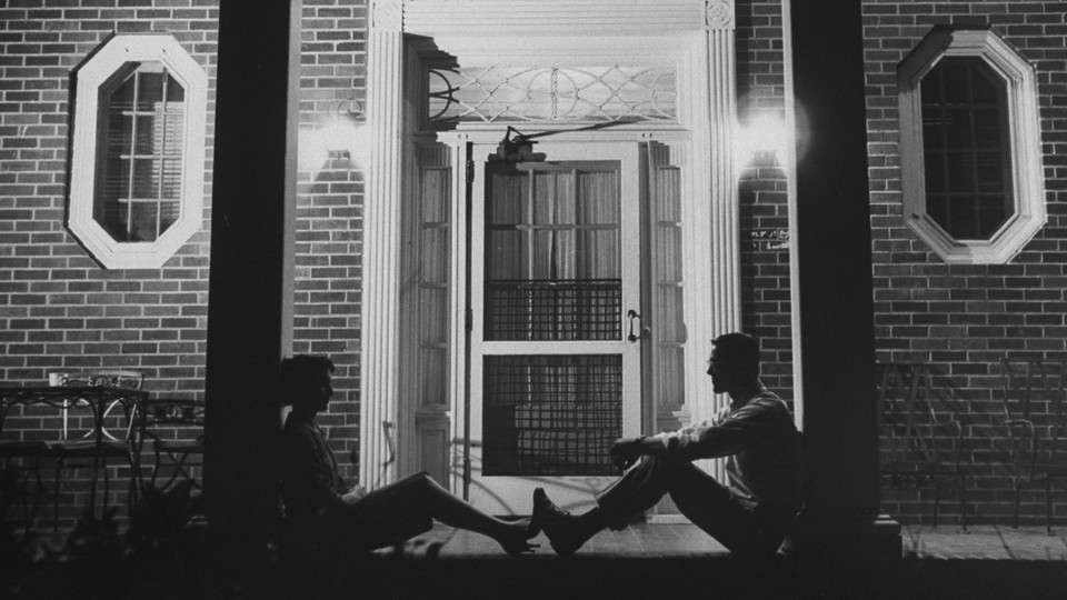 Image of two people in front of a building at night