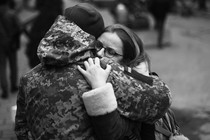 A Ukrainian soldier hugs his partner next to a military base where residents are queuing to join the army in Lviv.