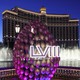 A display of footballs with a Super Bowl LVIII logo in front of the fountains of Bellagio