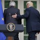 Trump places his hand on Juncker's back following a joint press conference at the White House Rose Garden. 
