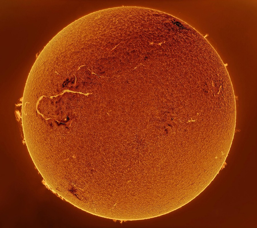 A view of the sun, using a filter on a telescope that makes our closest star resemble a fuzzy orange ball.