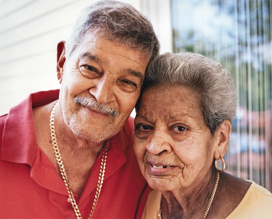 photo of smiling man with mustache in red shirt and woman with gold earrings