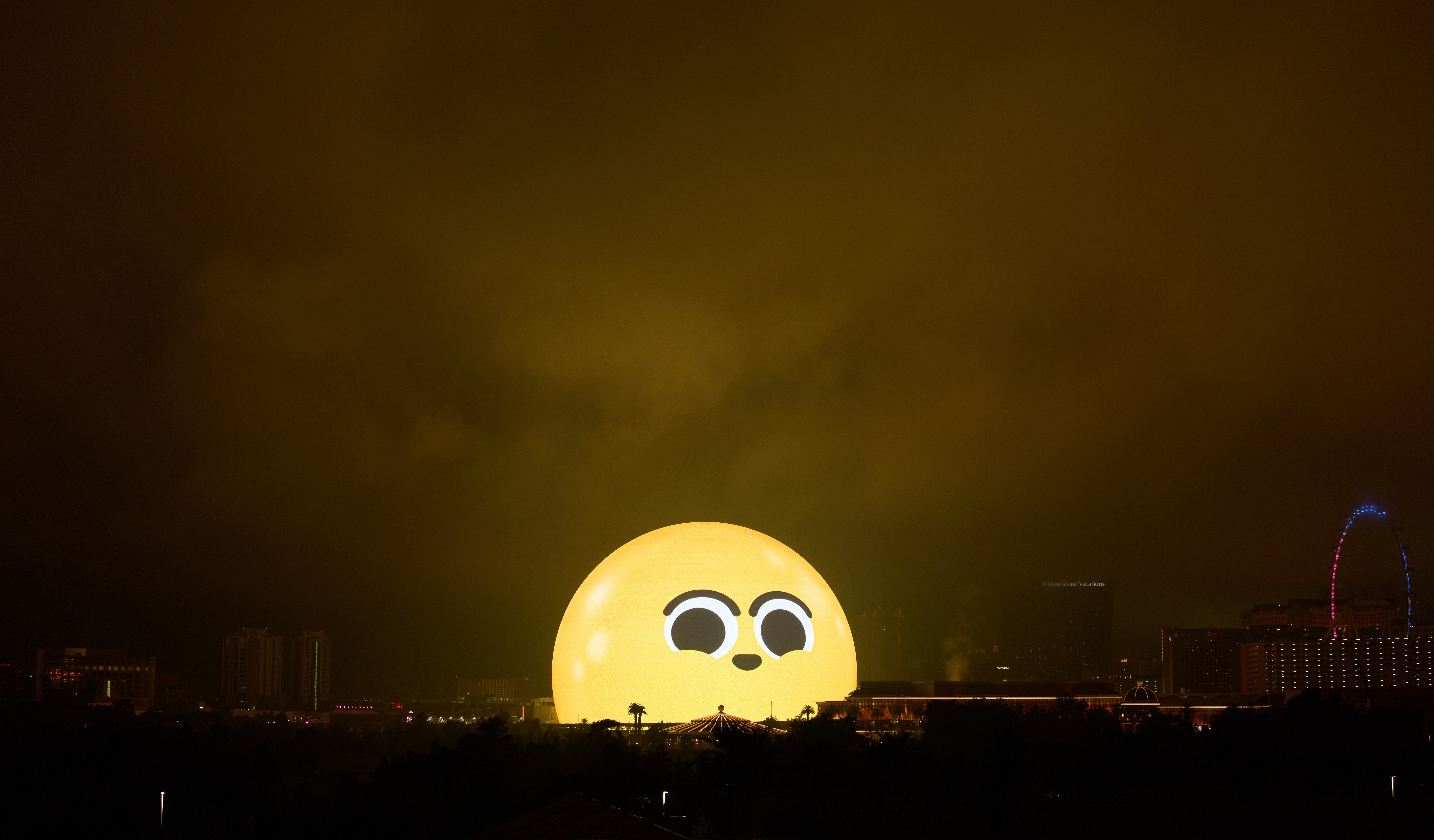 A large sphere shaped structure in Las Vegas, illuminated to look like a happy face emoji.