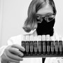 A woman in goggles with uncapped saliva samples