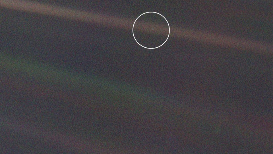 The planet Earth as a very small dot, seen through a sunbeam