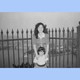 The author as a child with her mother near a gate, in black-and-white