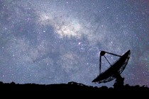 The Parkes Observatory, a radio telescope in Australia, at night with many stars overhead