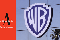 A view of the Warner Brothers logo on a building with a palm tree in the reflection