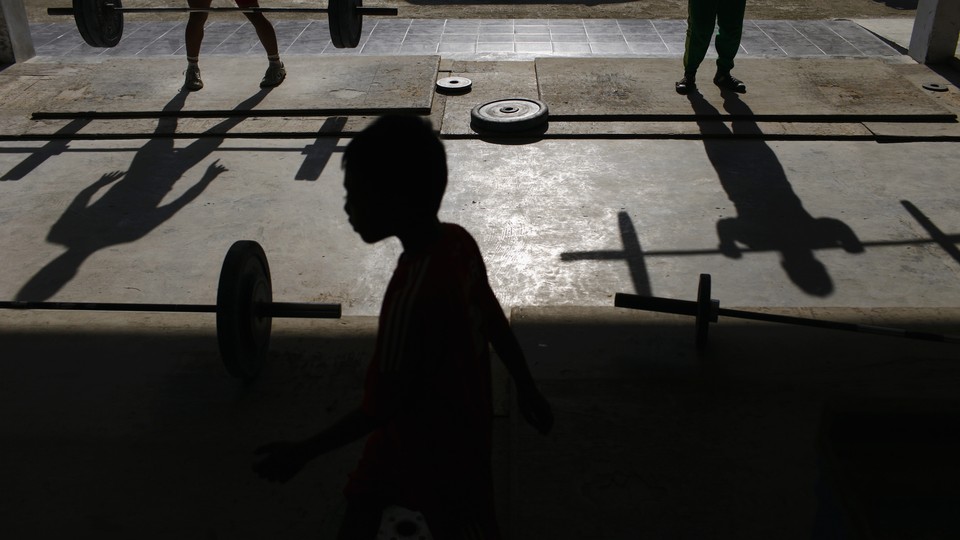 Silhouettes of boys lifting weights