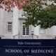 A man in scrubs walks outside the Yale School of Medicine.