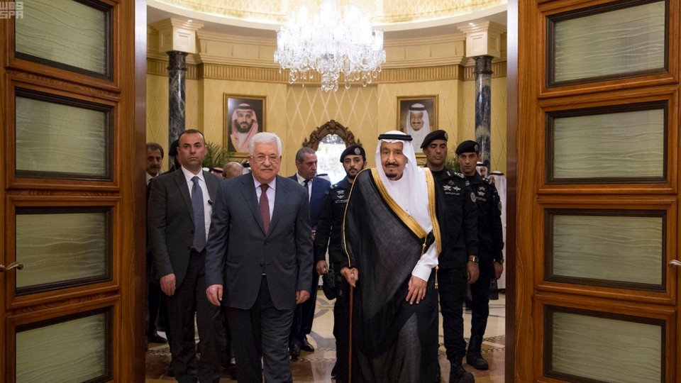 Saudi Arabia's King Salman bin Abdulaziz Al Saud walks with Palestinian President Mahmoud Abbas.