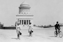 Two women and a man bicycle past Grant's Tomb in New York.