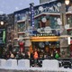 A color photograph showing people lined up outside the Egyptian Theatre on a snowy day at the Sundance Film Festival 2026 in Park City, Utah.