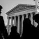 Three shadowy figures in front of the Supreme Court