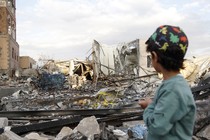 A child looks at a building destroyed by U.S. airstrikes in Yemen