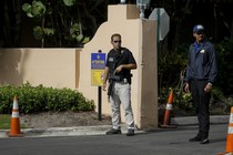 Two Secret Service agents stand at the Mar-a-Lago gates.