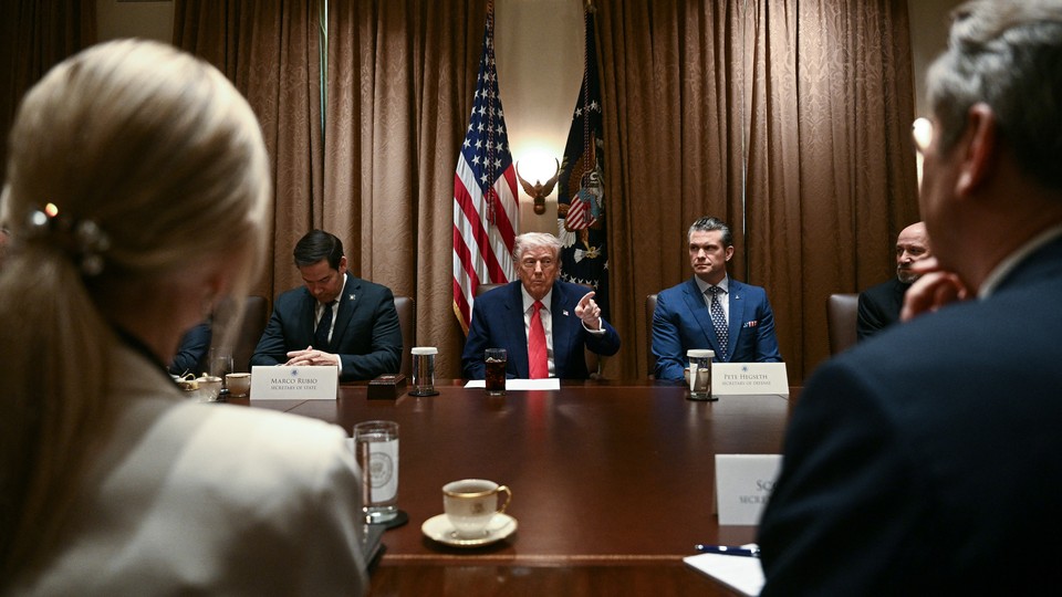 Donald Trump sits at a table next to Pete Hegseth and Marco Rubio
