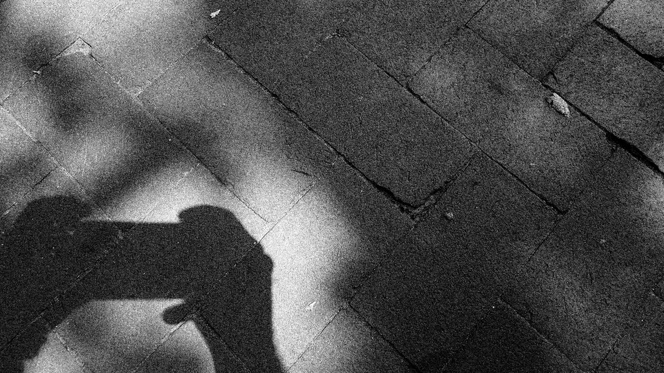 Photograph of a shadow of hands holding a smartphone