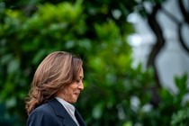 Kamala Harris smiles while looking down and walking