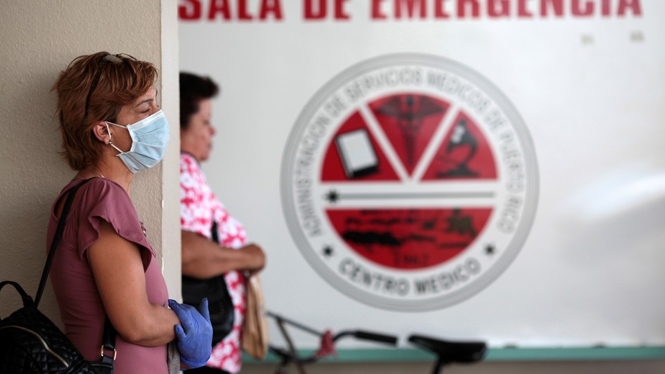 People wait outside the emergency room at the Medical Center inPeople wait outside the emergency room at the medical center in San Juan, Puerto Rico, September 25.