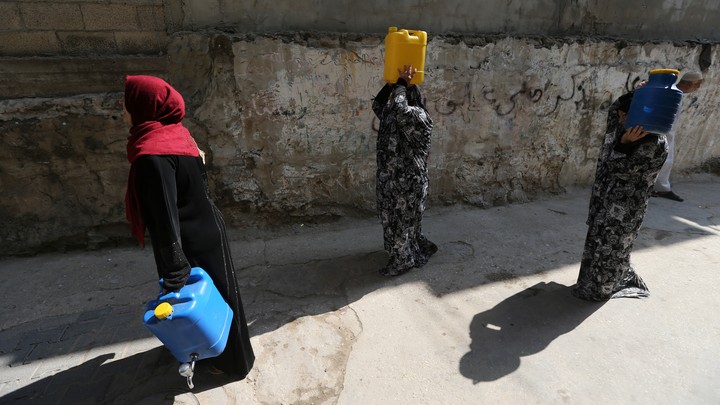 Palestinian women walk after fetching potable water in the Al-Shati refugee camp (also known as Beach Camp) in Gaza City, September 10, 2019.