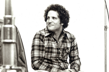 detail from black-and-white photo of Albert Brooks with film equipment on set