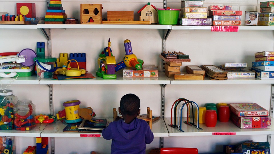 A kid stands in front of shelves of toys
