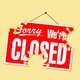 A sign that says SORRY WE'RE CLOSED, with coronavirus-shaped holes in it