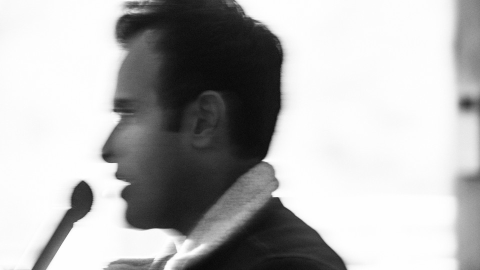 Blurry black-and-white photo of Vivek Ramaswamy speaking into a microphone