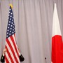 A worker adjusts the U.S. flag before Japanese Prime Minister Shinzo Abe addresses media following a meeting with President-elect Donald Trump in New York City on November 17, 2016. 