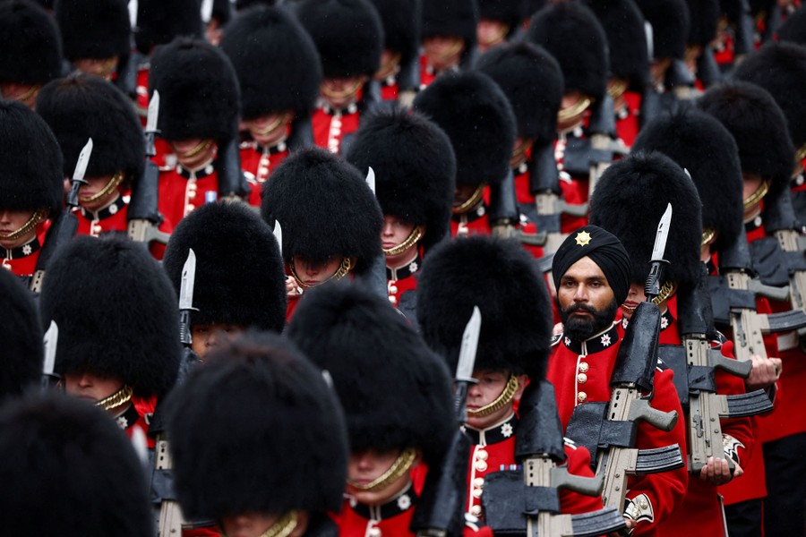 A view of rows of British soldiers in dress uniform, wearing tall fuzzy hats