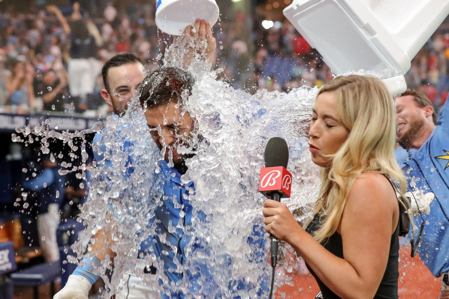A baseball player is doused in ice water by his teammates.