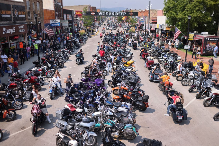 Hundreds of people and motorcycles line a street in Sturgis.
