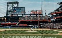 A photograph of a live baseball game from behind a net.