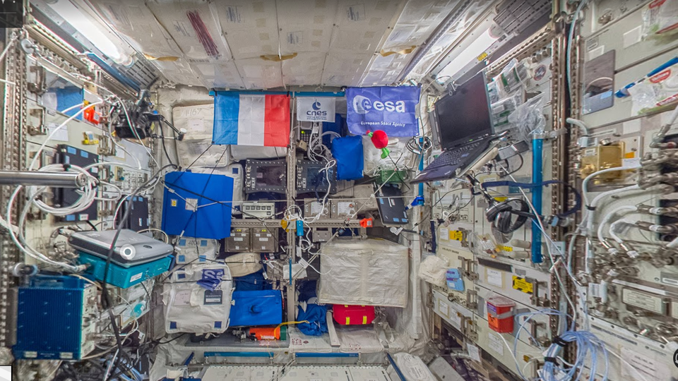 A crowded space full of electronics and a French flag