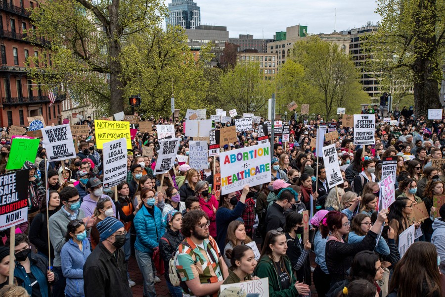 A large crowd of protesters hold up signs supporting abortion rights.
