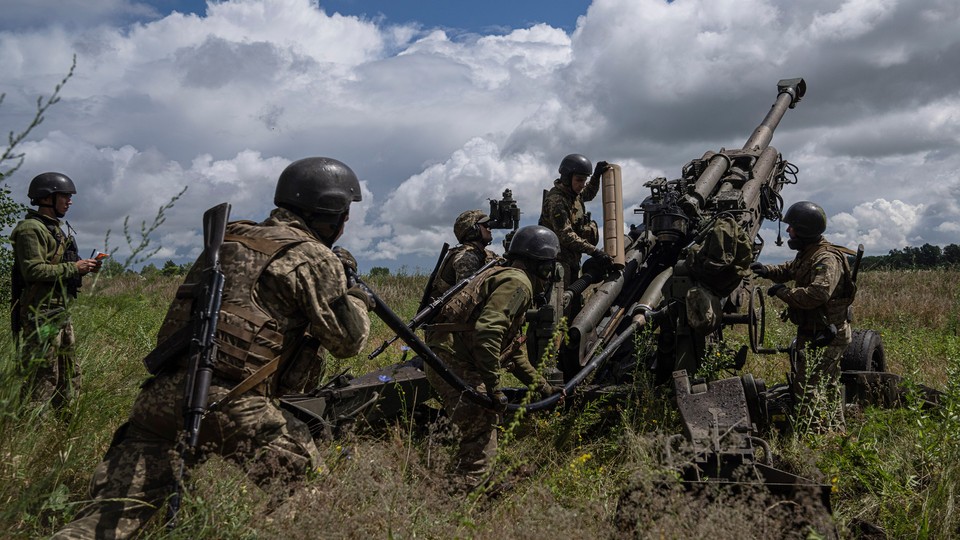 Ukrainian service members prepare to fire at Russian positions.