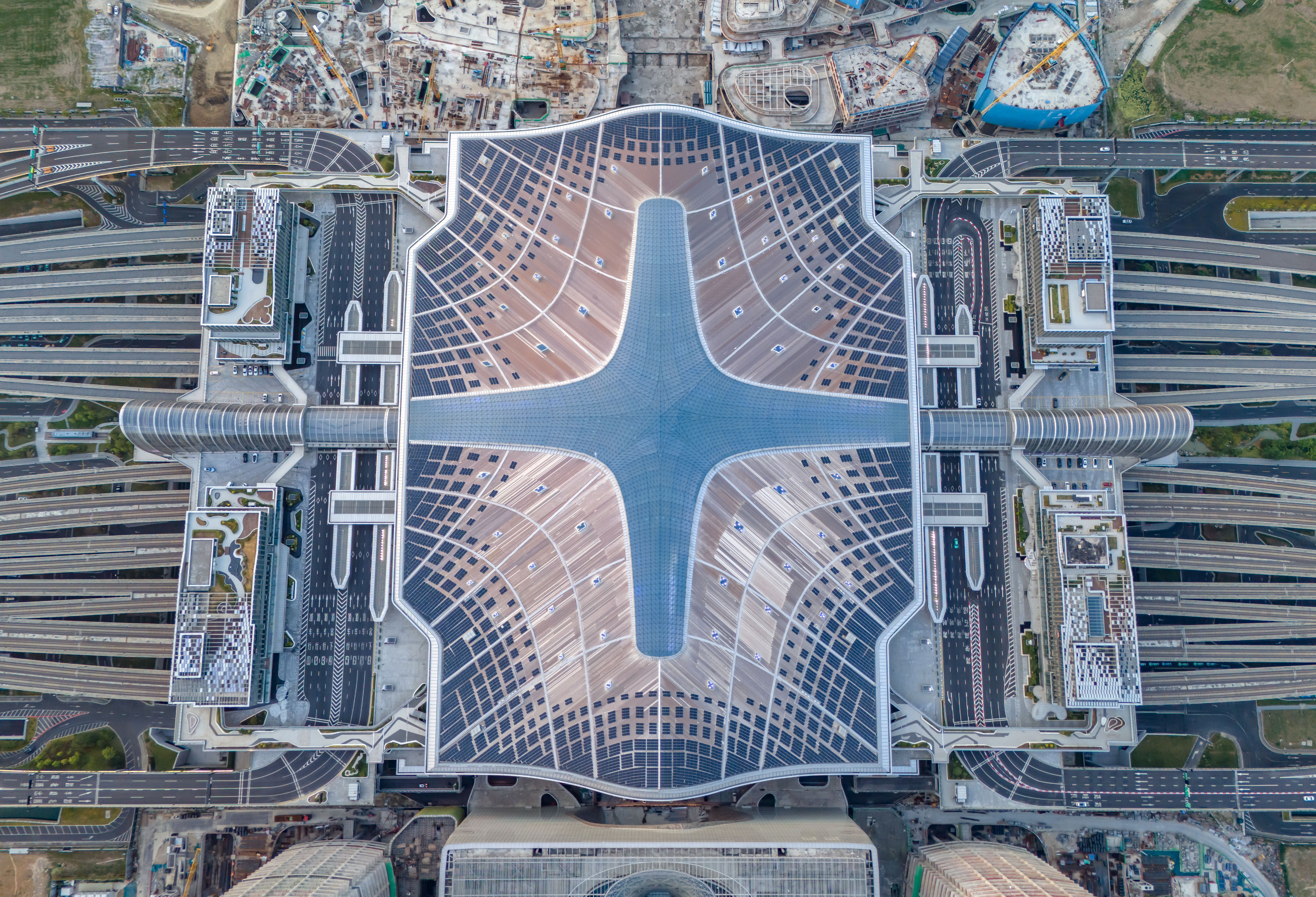 An aerial view of many solar panels artfully placed on the roof of a new train station.