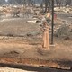 A statue stands in a backyard, amidst the rumble of a destroyed home. 
