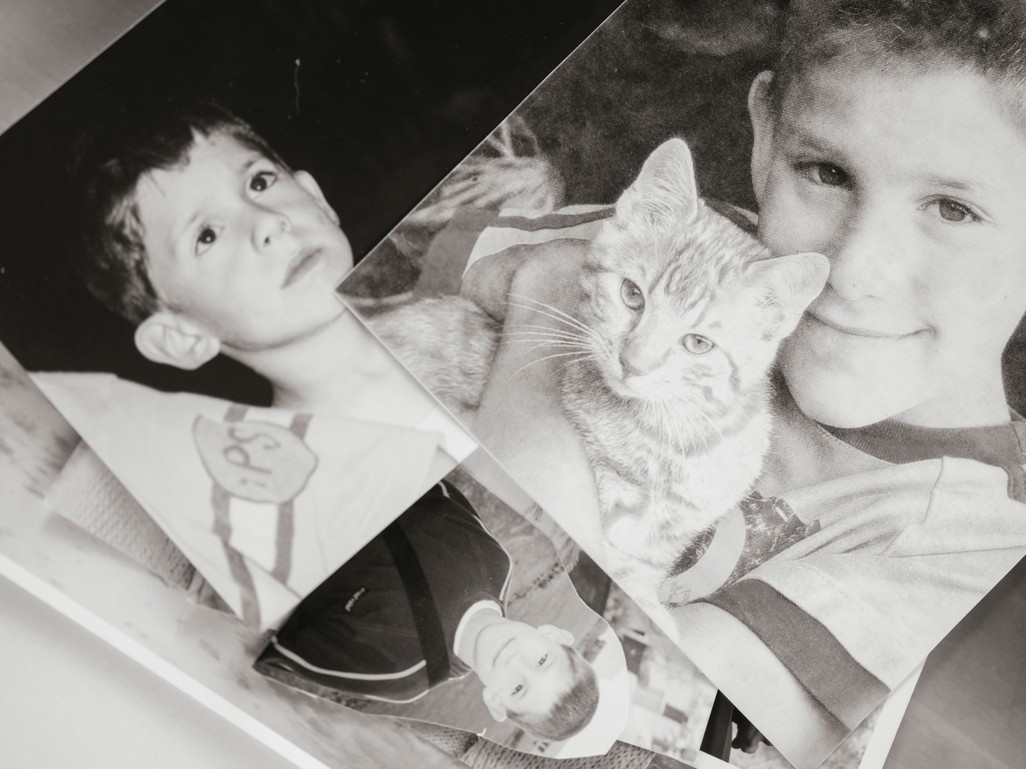 photo of stack of black-and-white photos of young boy, one with kitten