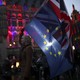 A woman holding the European Union and Union Jack flags.