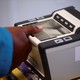 A woman places her thumb on a fingerprint scanner.