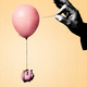 Illustration of a piggy bank held up by a balloon and someone preparing to pop the balloon with a needle