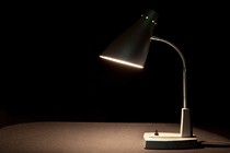 A lamp on a desk against a dark background