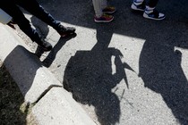 Shadows of students and their sneakers waiting for a school bus