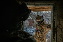 A Ukrainian soldier stands in a doorway