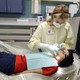 A female dentist treats a patient