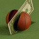 Illustration of a dollar bill slicing a basketball in half