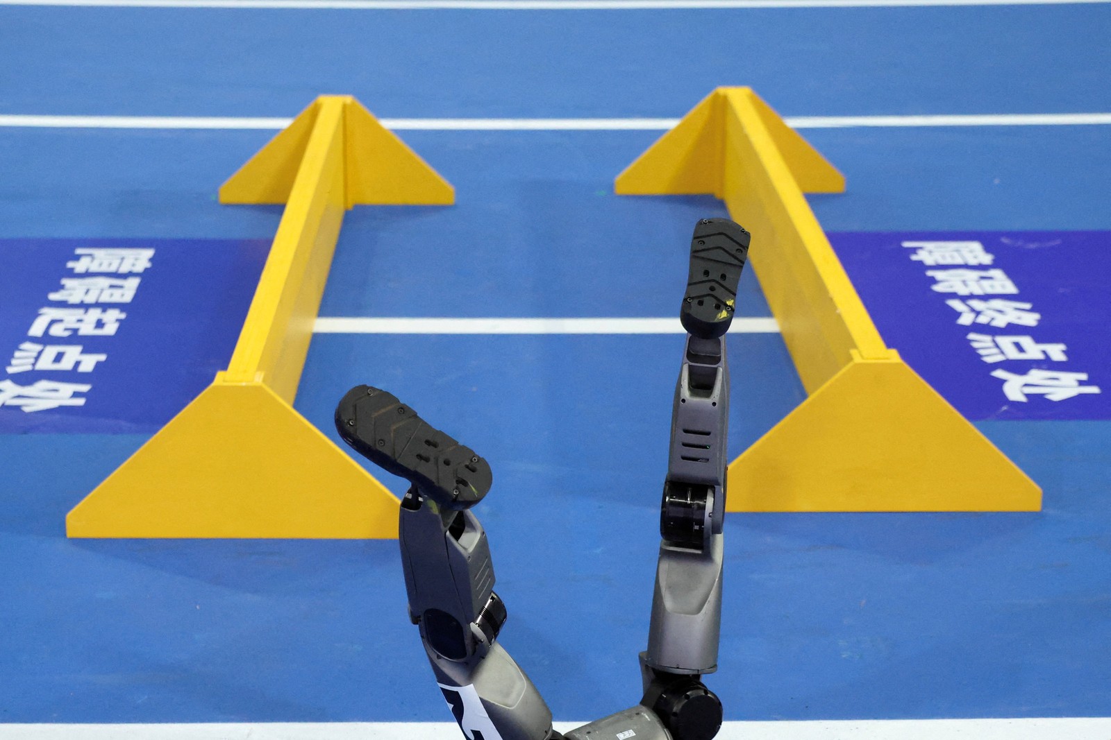 The feet of a humanoid robot stick up, after it fell during an obstacle race.