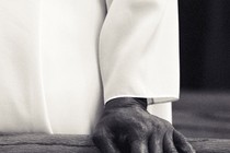 close-up of a hand resting on a pew